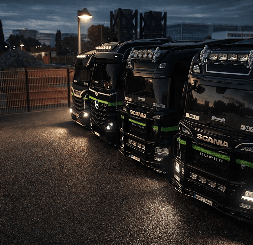 A convoy of trucks hauling freight past open farmland.